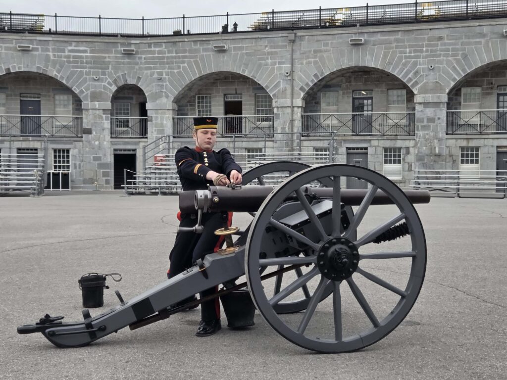 a soldier performing a live demonstration of how to fire a cannon