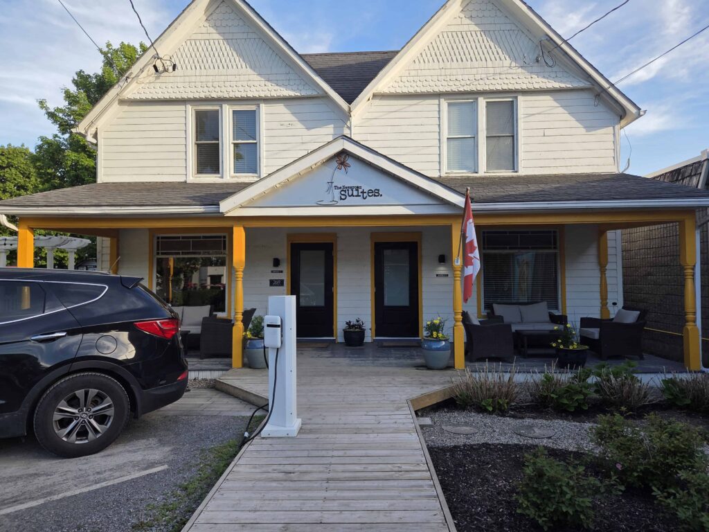The outside of the Newsroom Suites is cheerful and has limited parking and 2 comfortable sitting areas on a porch in the front