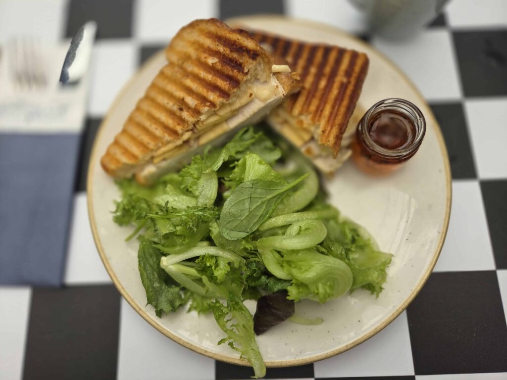 grilled turkey, apple, and brie on grilled sourdough bread, together with a lettuce salad