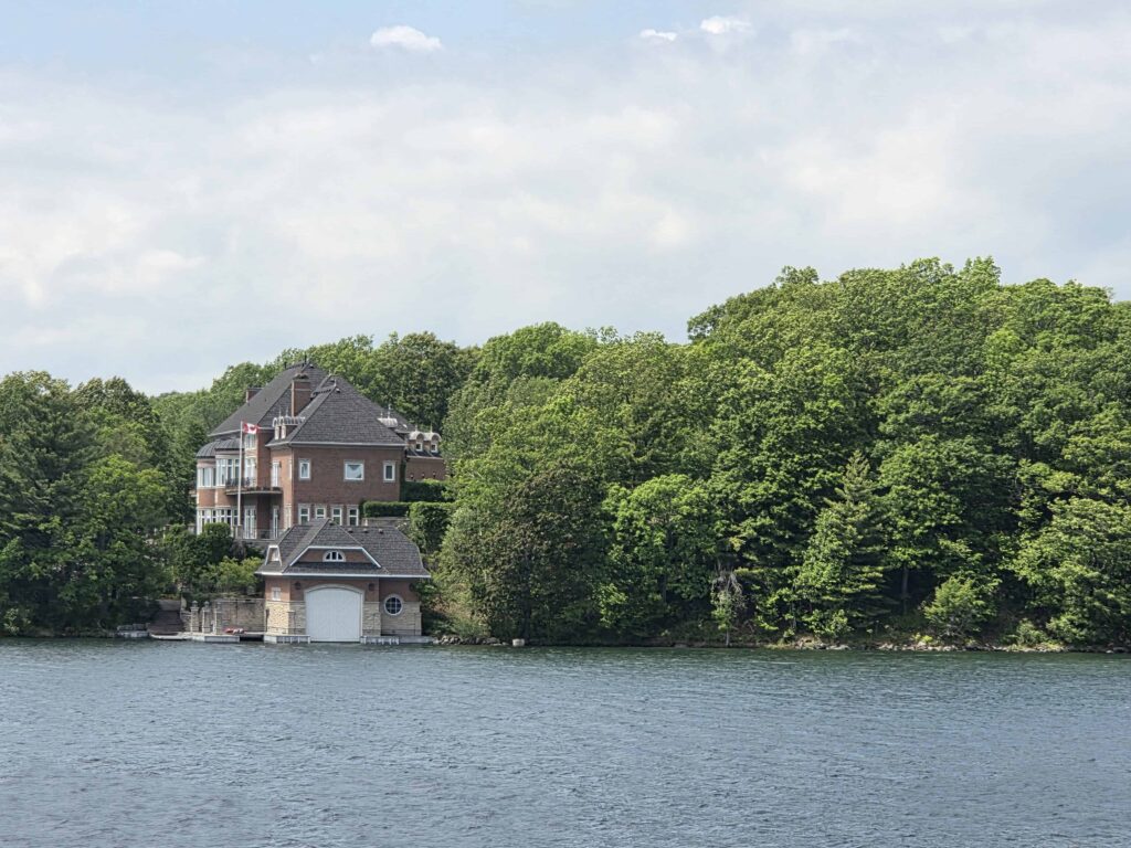 There are many large homes and cottages surrounded by greenery and the St. Lawrence River