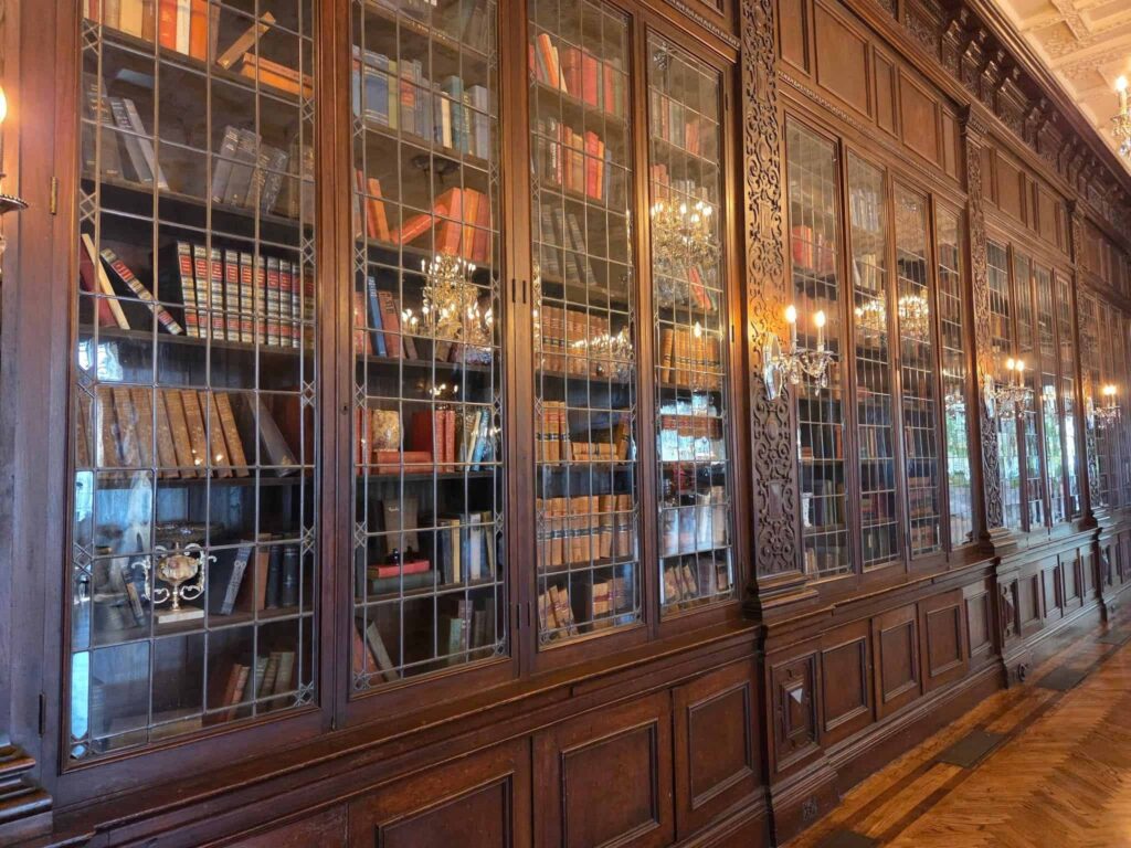 The grand library filled with hundreds of books and has wall adourned with mahogony wood