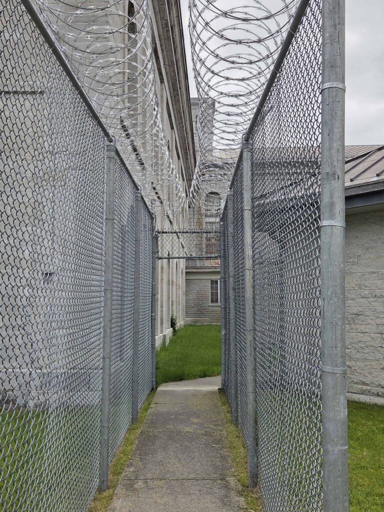 the gated alley leading from the prisoners cell block into the yard where the prisoners have 1 hour a day in sunlight