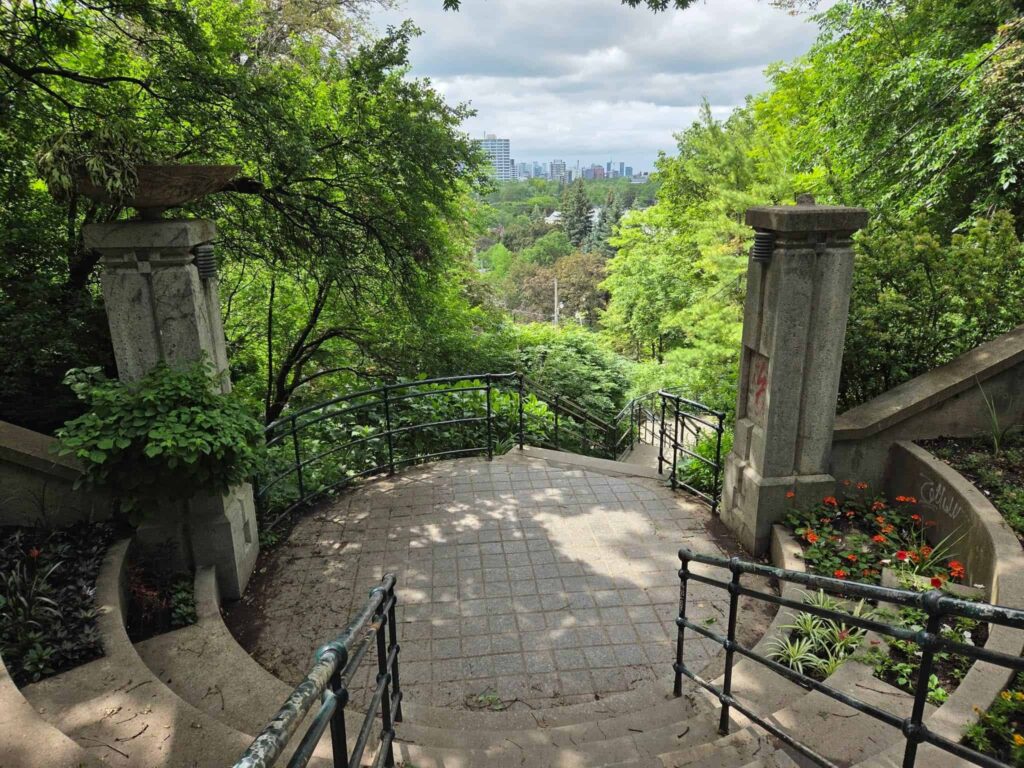 110 steps leading up to Casa Loma surrounded by greenery and beautiful gardens over-looking the city far in the distance