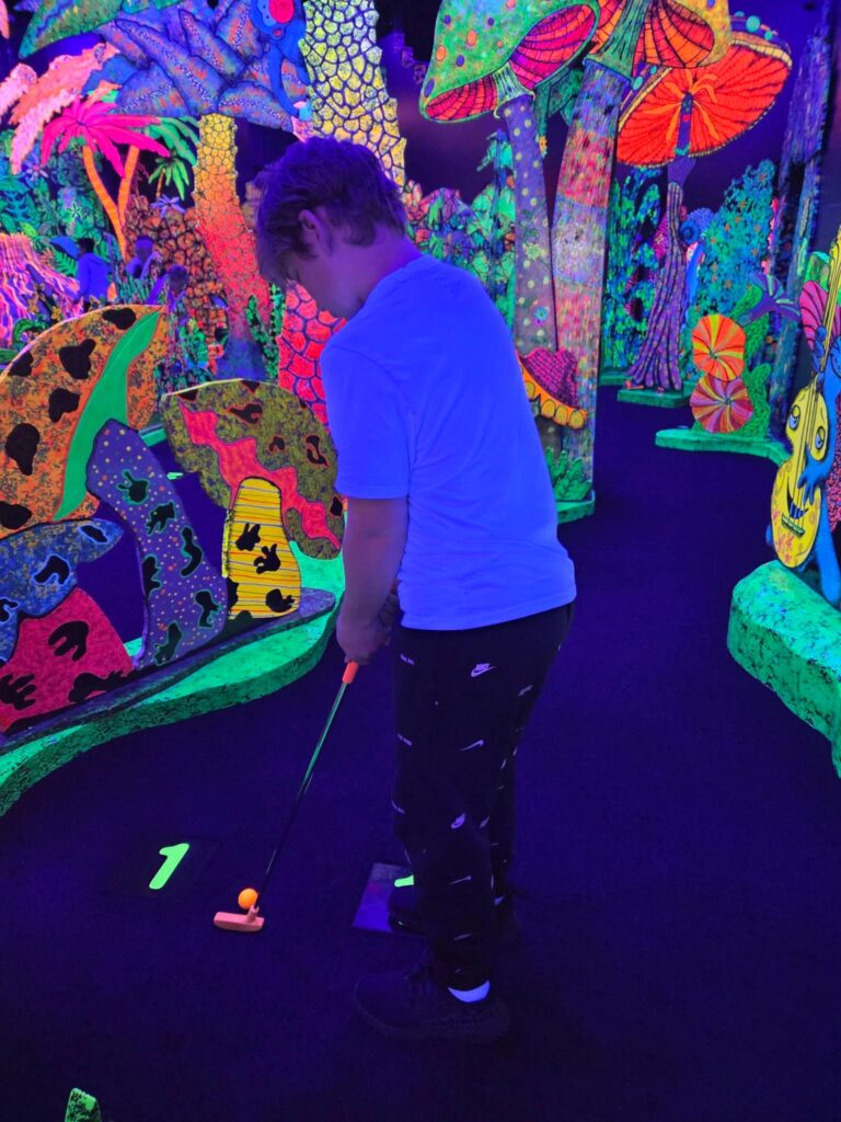When it's rainy or cold, play a game of mini golf at Putting Edge, an indoor glow in the dark mini golf course